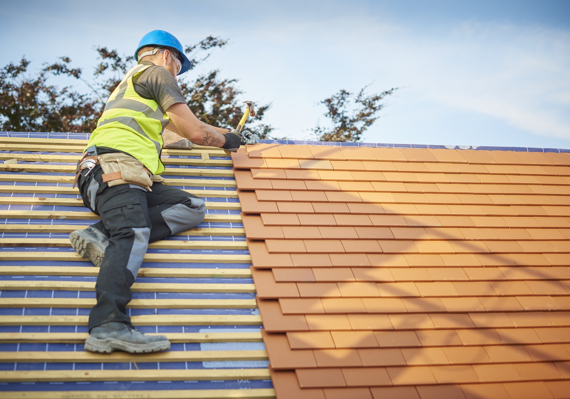 Construction worker on a rooftop with tools