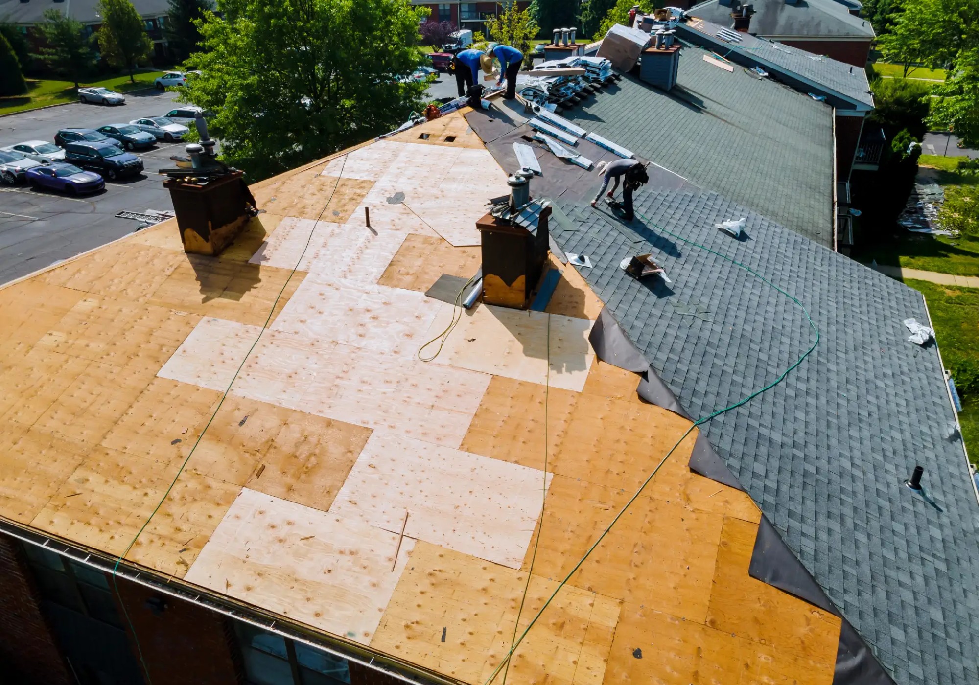 Workers installing shingles on a roof