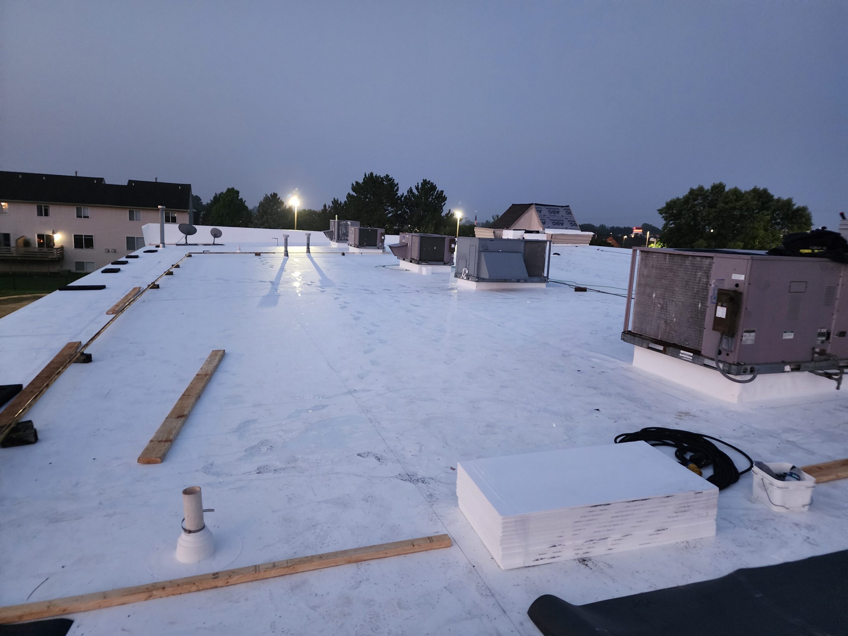 Flat rooftop with HVAC units at dusk.