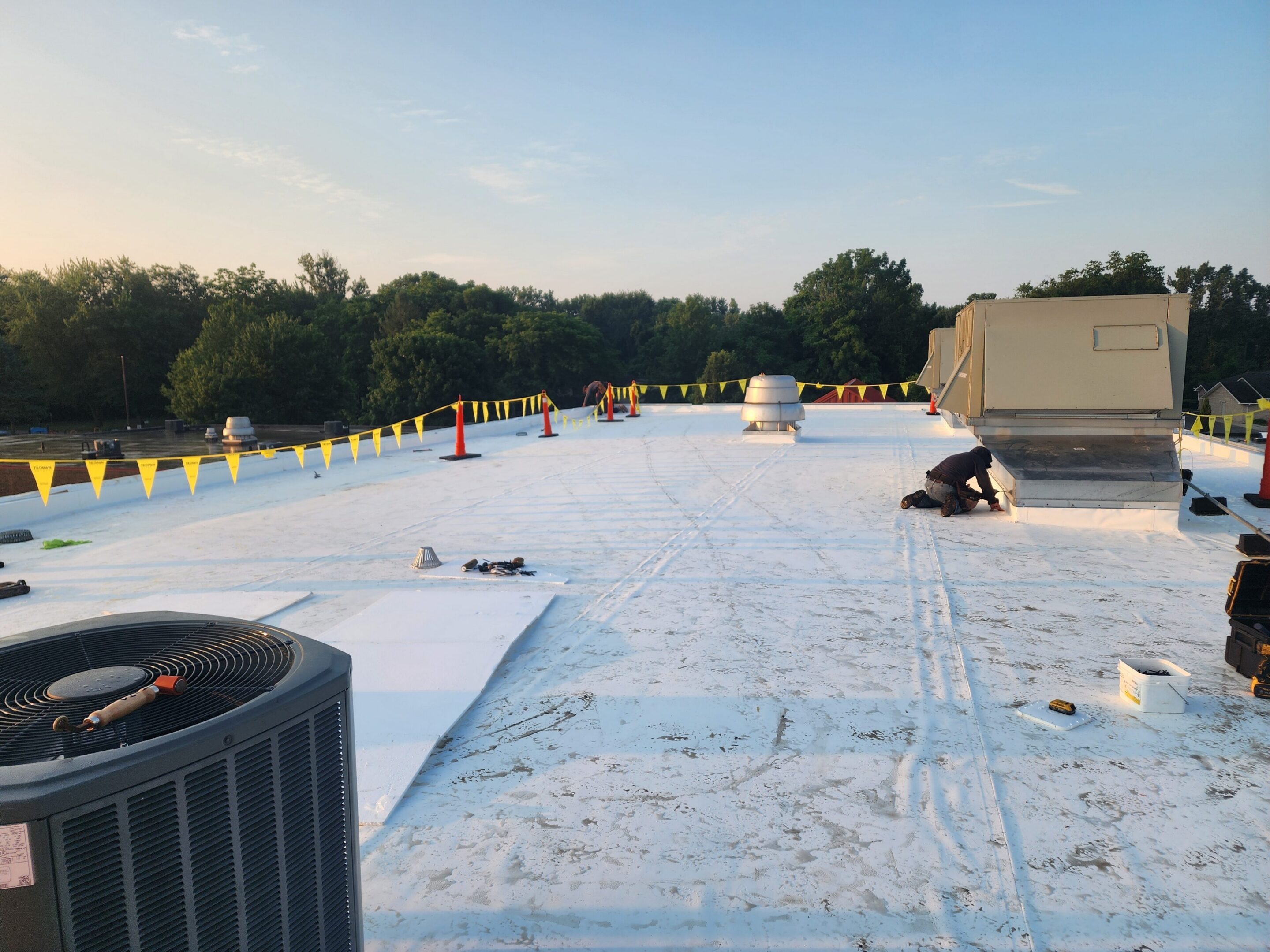 Rooftop construction with equipment and safety barriers.