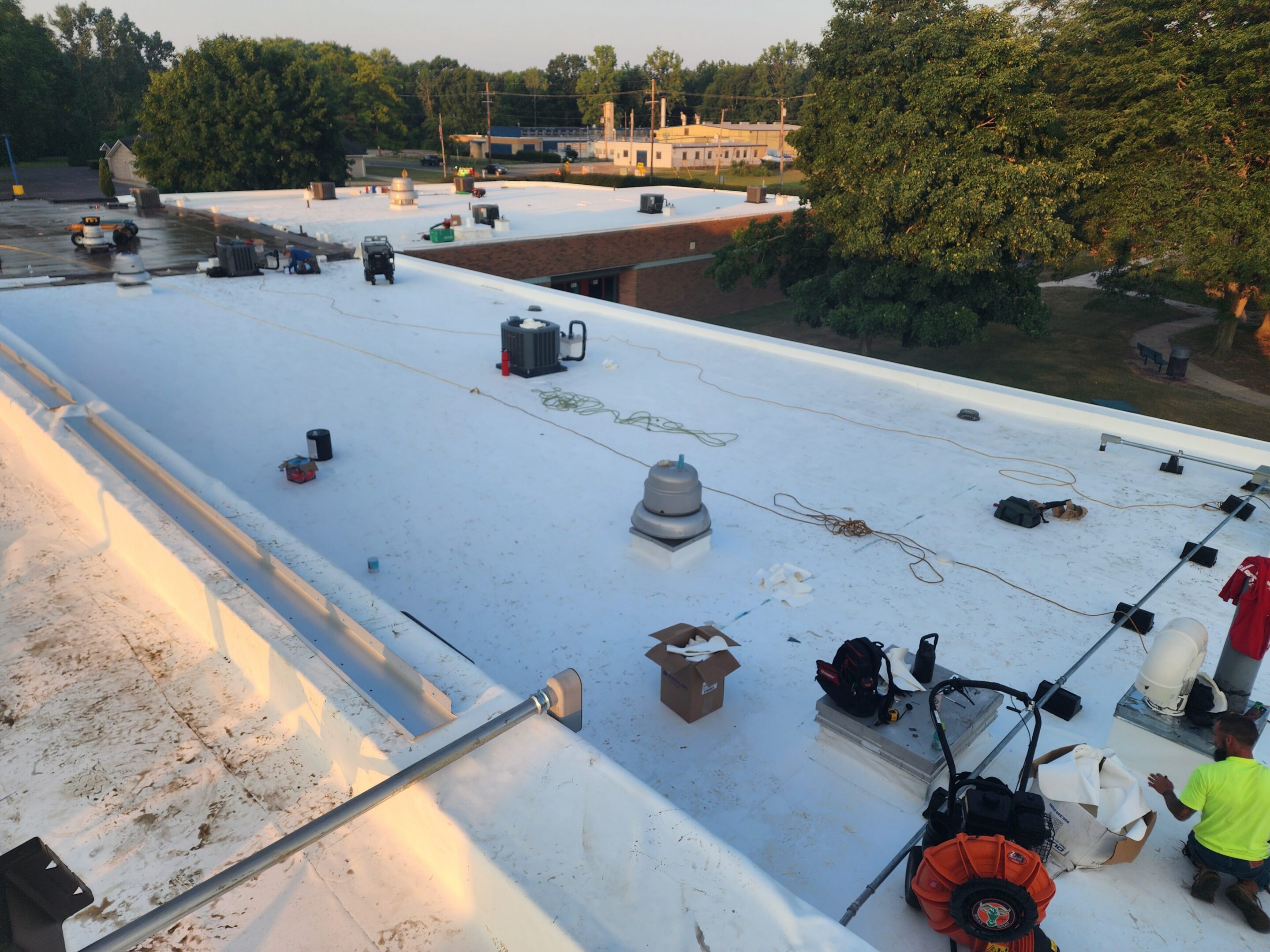 Workers on a large, flat rooftop.