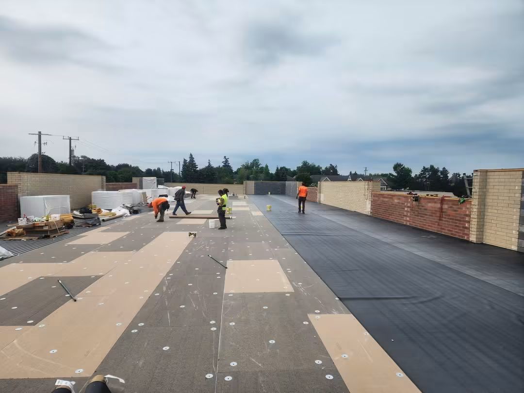 Workers installing flat roof panels.