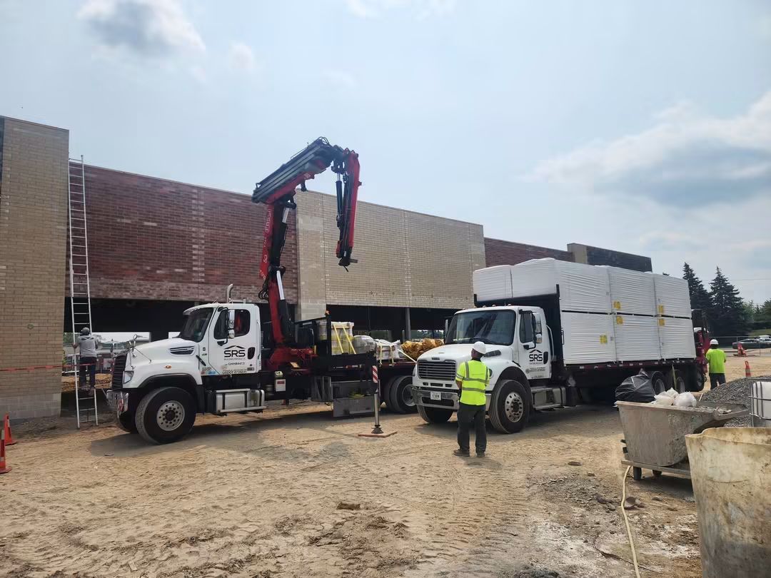 Construction site with trucks and workers present.