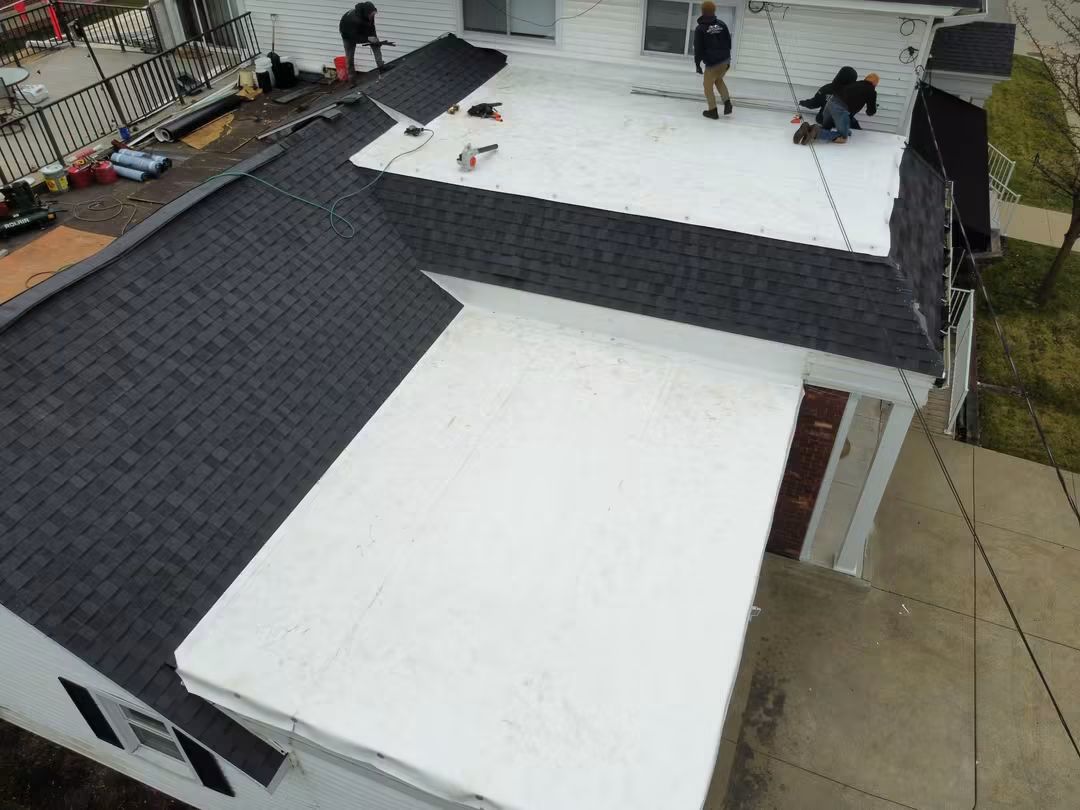 Workers installing a flat white roof.