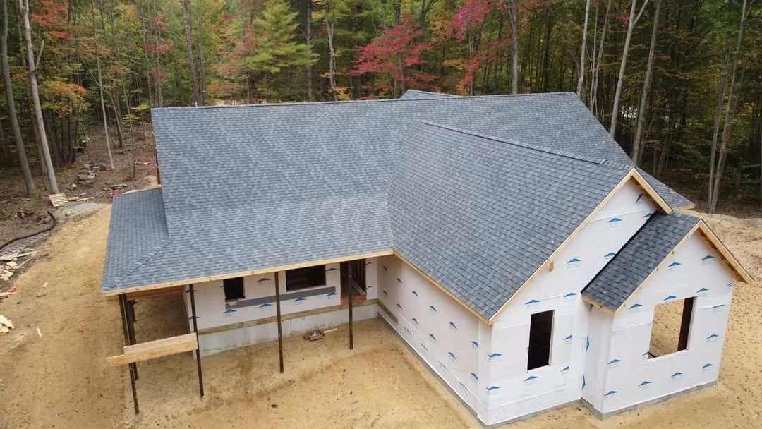 House under construction in wooded area.
