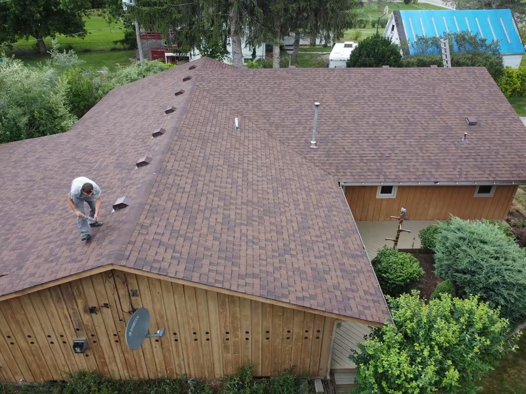 Man working on a large brown roof.